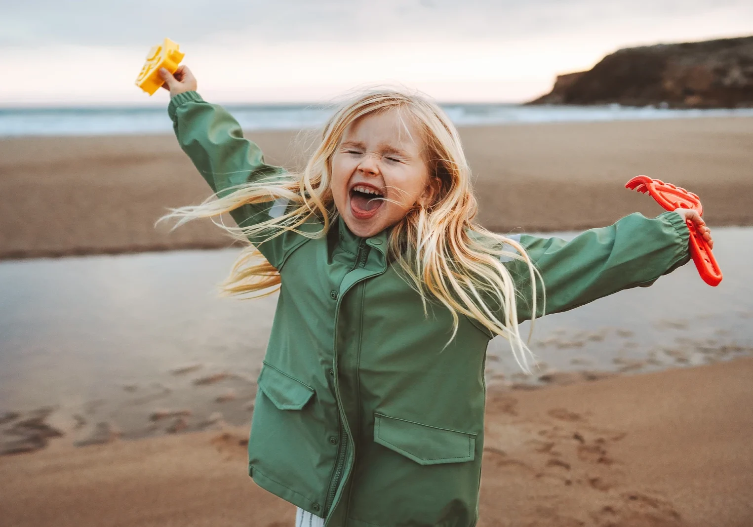 Meisje gelukkig lachen spelen buiten familie levensstijl vakanties emotioneel kind glimlachend wandelen met speelgoed op het strand